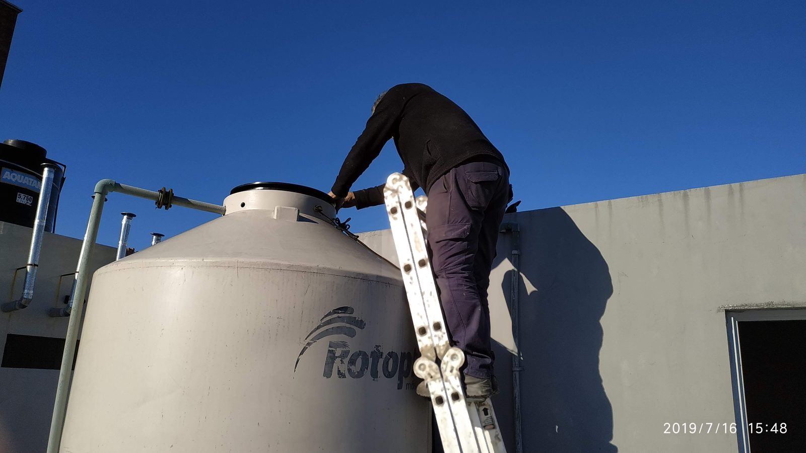 Operario de Megaclor subiendo a un tanque de agua elevado para su limpieza